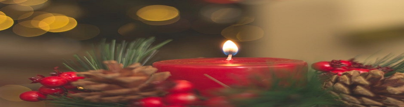 Candle surrounded by wreaths and holiday decorations