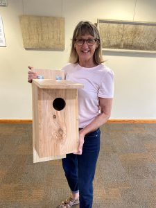 Woman holding an eastern screech owl nest box