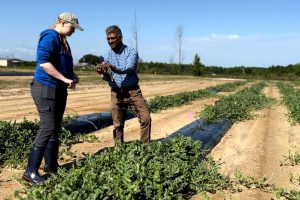 Professor Mathews Paret standing in field with student