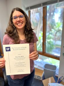 Erica Goss standing in office holding award
