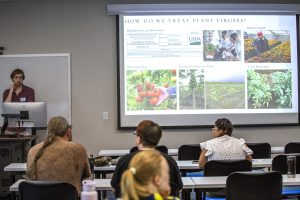 person in front of classroom with slide on projector screen