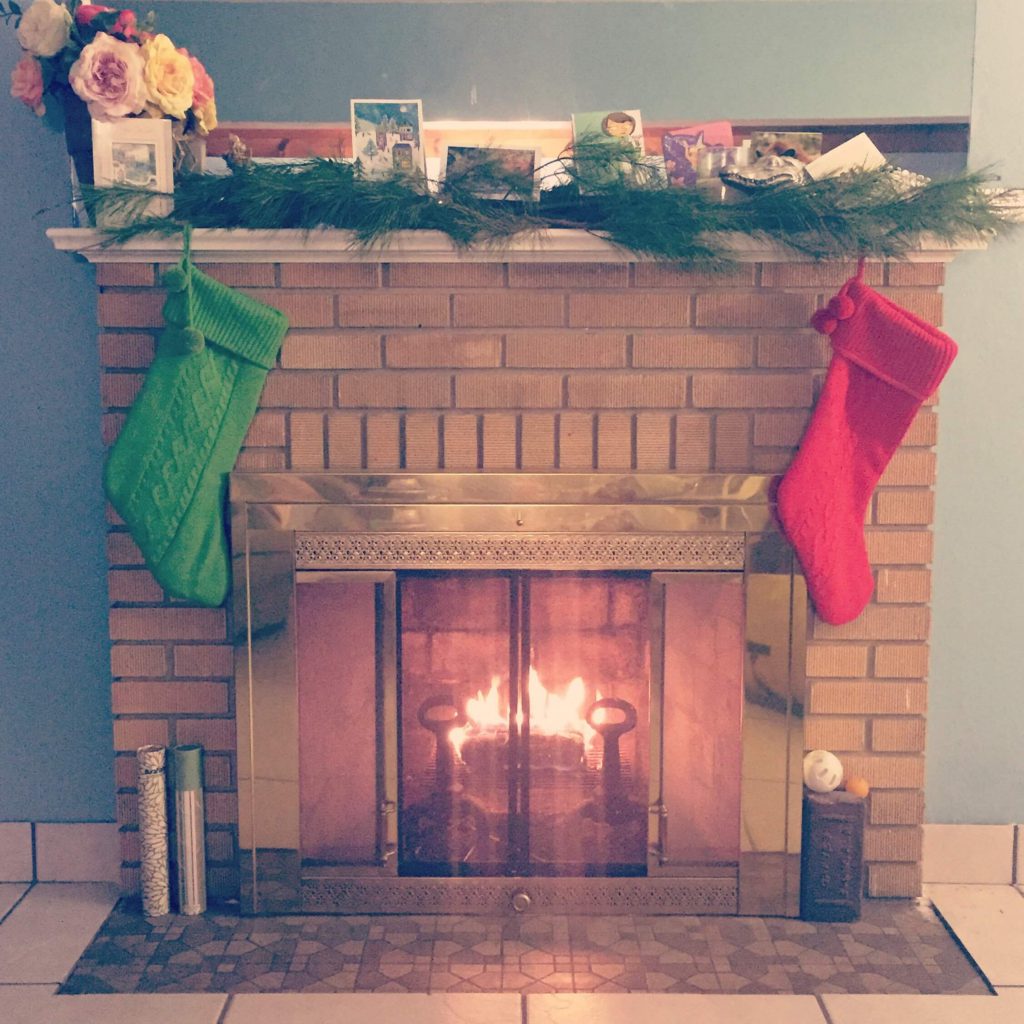 A cozy fireplace with native sand pine branches used for a mantlepiece garland.