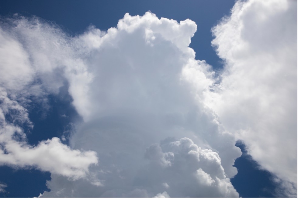White puffy clouds against a dark blue sky