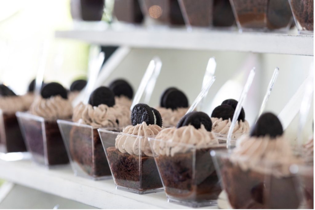 A row of chocolate desserts sits on a white display.