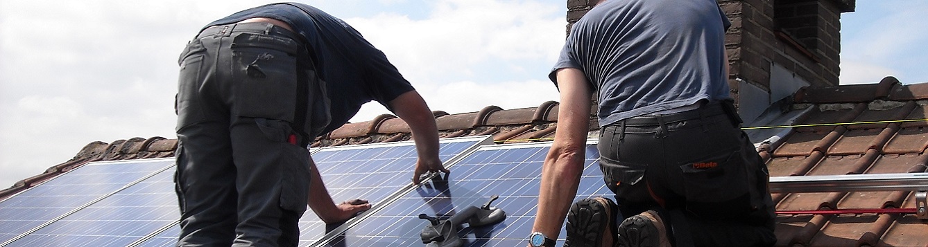 Workers install rooftop solar panels