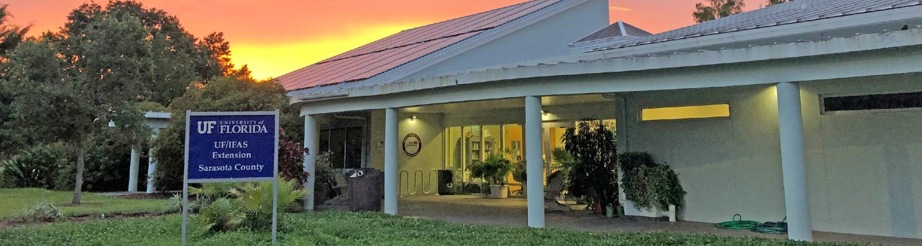 exterior shot of UF/IFAS Extension Sarasota County, with red-orange sky in background as sun sets