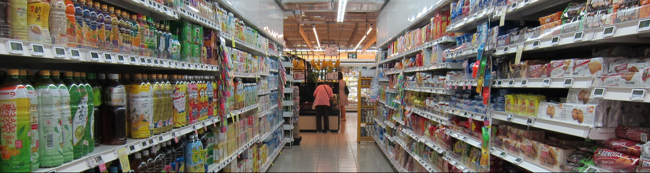 A grocery store aisle with products stacked on shelves. [CREDIT: Pixabay.com]