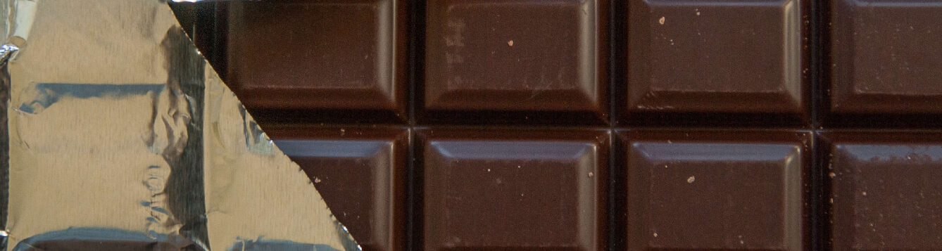 A dark chocolate bar, partially unwrapped to show the treat. [CREDIT: Pixabay.com]