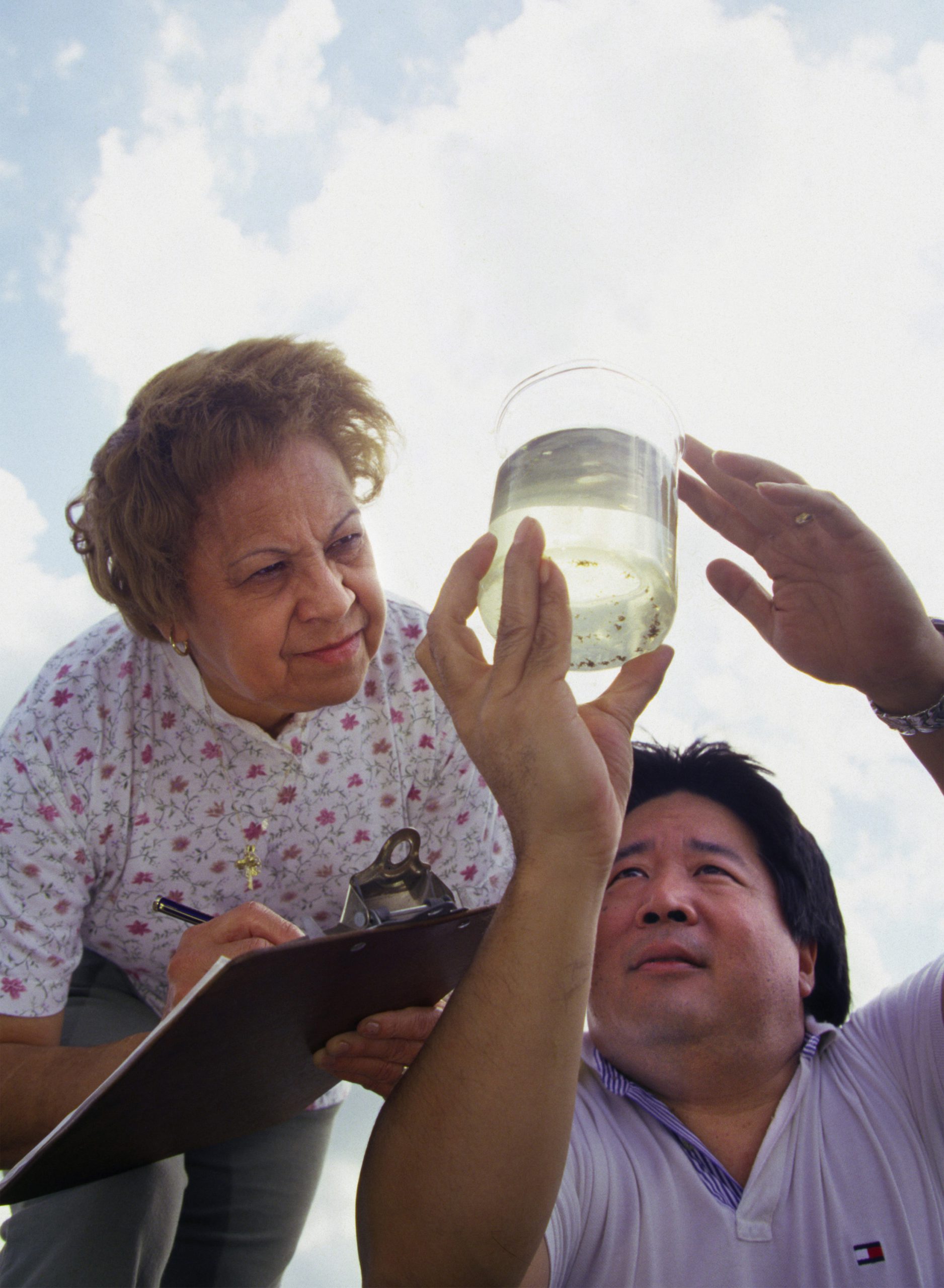 Photo of two people examining a beaker of water