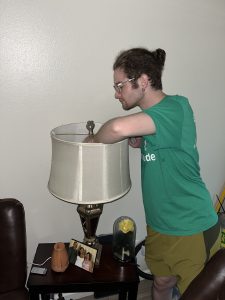 Picture of an Energy Coach changing out an incandescent lightbulb for an LED