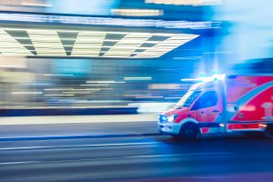 An image of an ambulance moving fast, with a blurred background.
