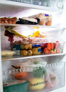 a look inside a refrigerator with an array of fresh and processed foods lining the shelves. [creidt: unsplash.com, darrien staton]