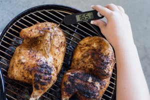 a food thermometer testing chicken on a barbecue grill shows a reading of 165.3 degrees F, within a safe zone. [credit: uf/ifas, tyler jones]