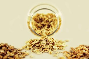 whole-grain cereals pour from a glass jar into a pile, with other piles nearby, on a flat, empty tabletop. [credit: pixabay.com, angelica vaihel]