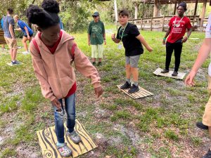 Campers playing a river crossing game during summer camp at Myakka River State Park