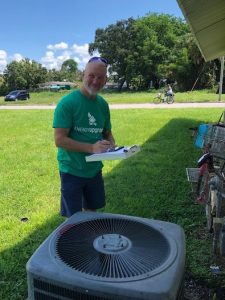 Energy Coach Volunteer assessing a residents Heating Ventilation Air Conditioning (HVAC) system for efficiency issues.