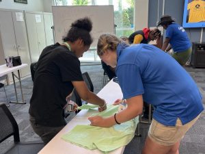 uf/ifas extension sarasota county intern kate albertus (foreground, blue shirt) helps a summer youth camper during a clothing preparation exercise. [credit: uf/ifas extension sarasota county]