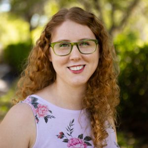 Woman (Ashley Worsham) poses for a headshot in nature.