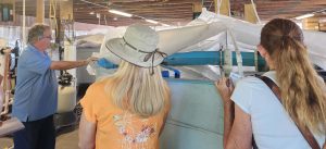 Lab manager showcases pool of mosquitofish in front of tour group