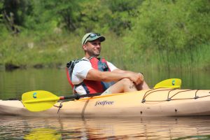 An image of a man kayaking in a river.