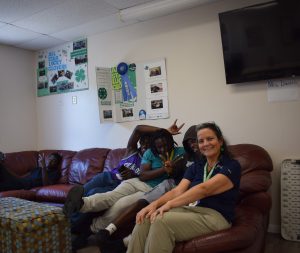 Students sit on a couch with their 4-H county agent