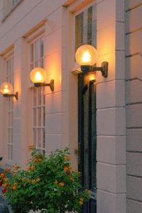 Circular bulb outside of a house shining light all over with no shield