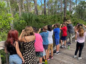 An image of a group of children using binoculars outside.