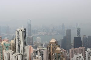 photo of tall city buildings, a river, and smog