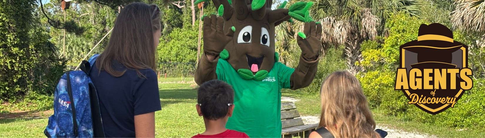 someone dressed as a tree out in a park with a family
