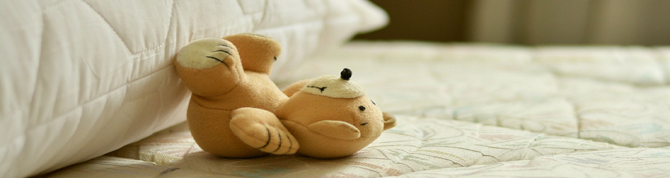 teddy bear on a sheetless matress