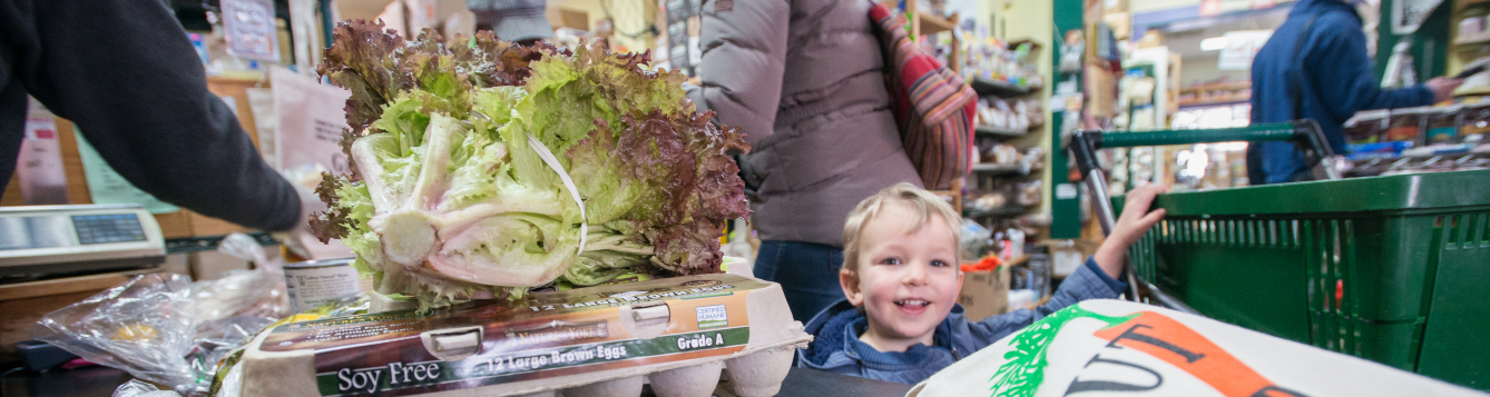a child smiles at the checkout line in a food store