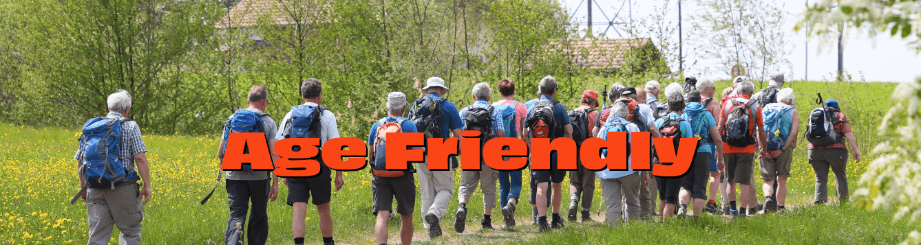 a group of hikes, including many older adults, treks along a trail through a grassy area. [credit: pixabay.com, roy buri]