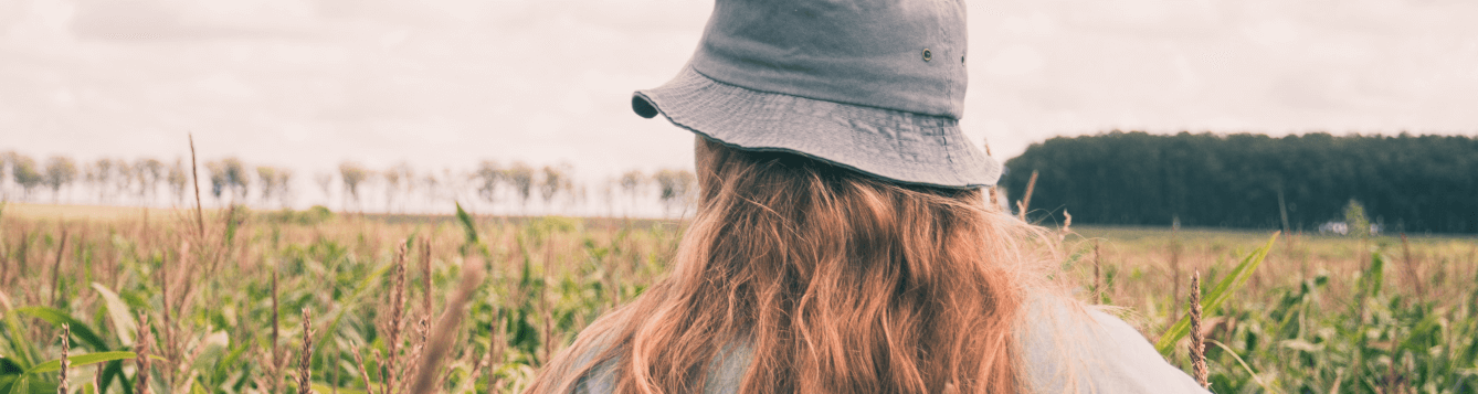a woman walks through a corn field and scans growing crops. [credit: unsplash.com, gonzalo facello]