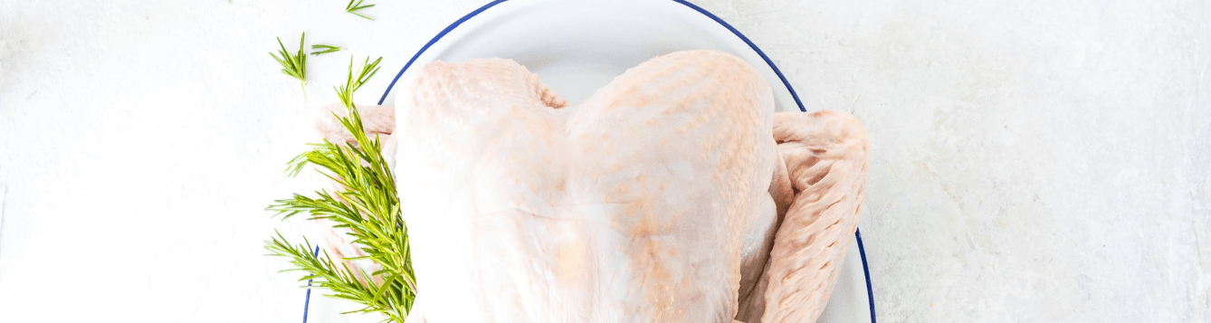 an uncooked, thawed turkey sits on a platter, awaiting cooking. [credit: unsplash.com, hayley ryczek]