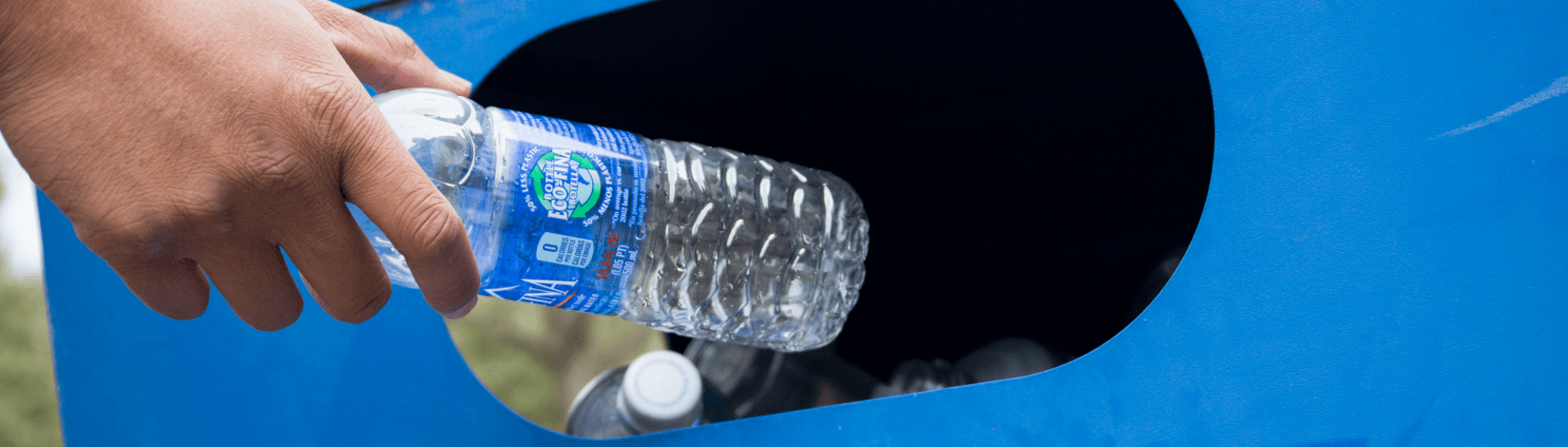 a hand with an empty plastic water bottle reaches into a blue bin to recycle the waste. [credit: uf/ifas, tyler jones]