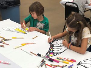 Picture showing campers decorating insect wings.