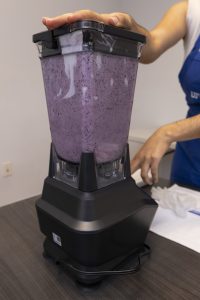 A blueberry smoothie being prepared in a blender.