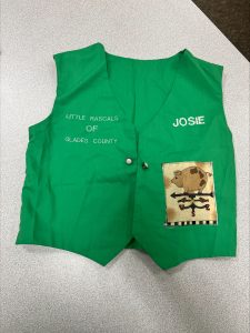 Green 4-H vest for a child on a table