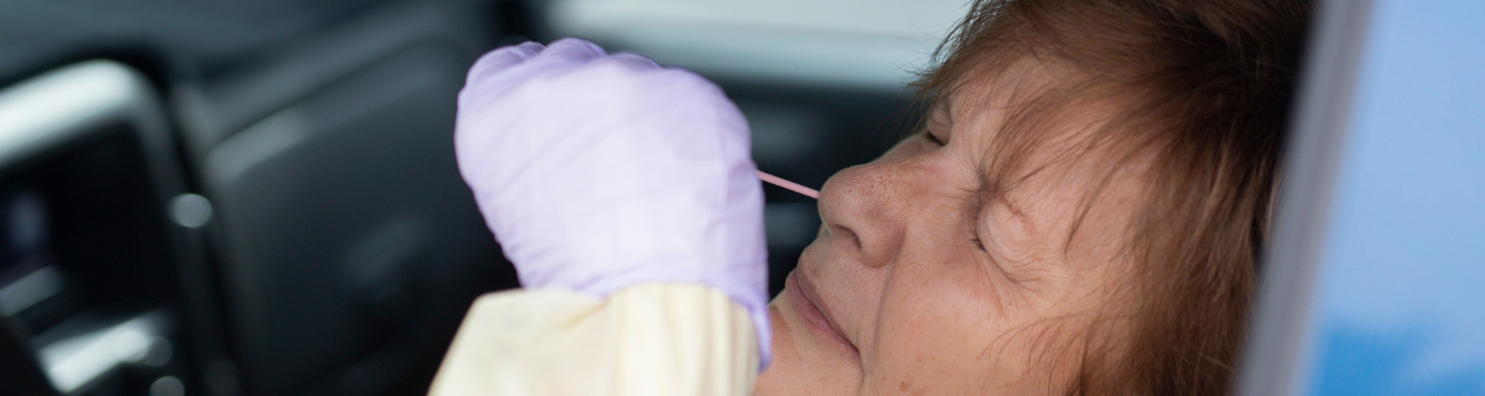 woman getting COVID test in car