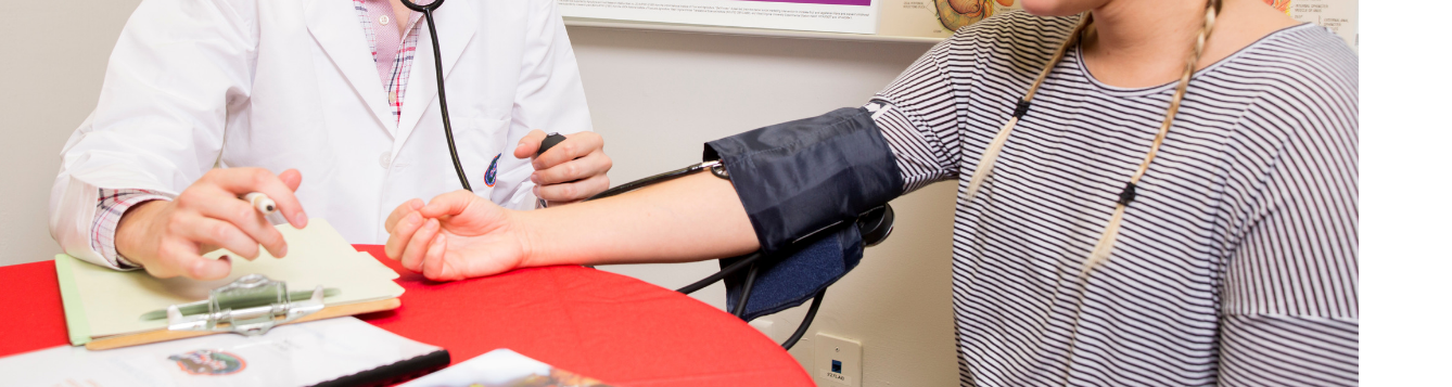 doctor taking a woman's blood pressure