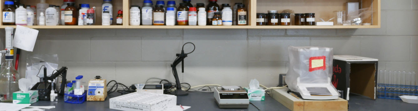 Lab bench with analysis equipment and chemicals.