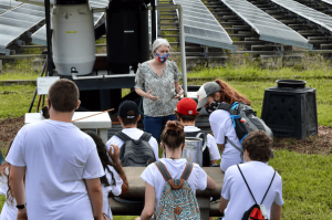 University professor discusses composting with group of students.
