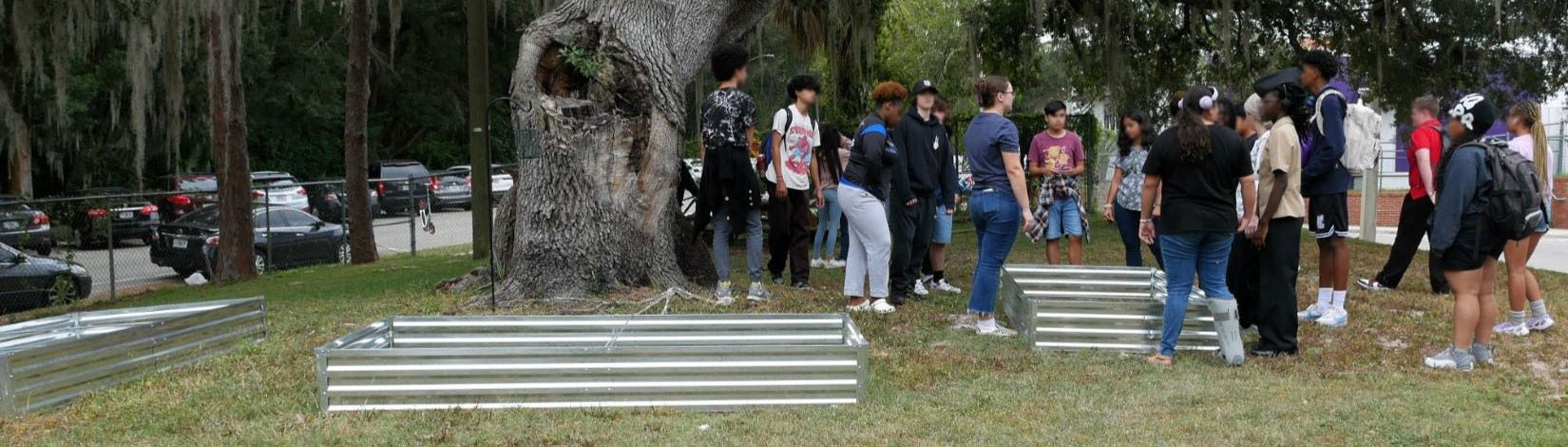 high school students standing around raised garden beds