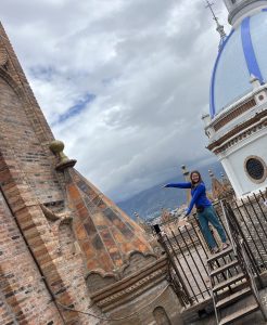Woman standing in front of historical buildings in Cuenca, Ecuador.