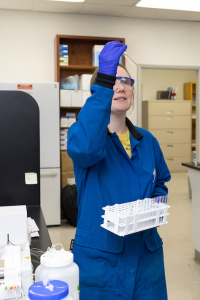 Two men in a lab stand over soil and water analytical equipment.