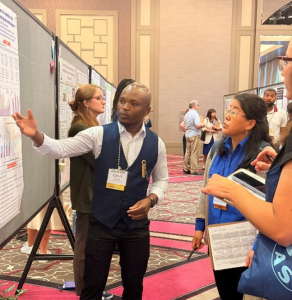 A graduate student explains his soil science research poster to attendees at the ASHS annual conference.