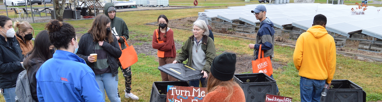 College students examining a composting operation