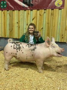 Liz Newman posing with her Grand Champion Hog after the swine show