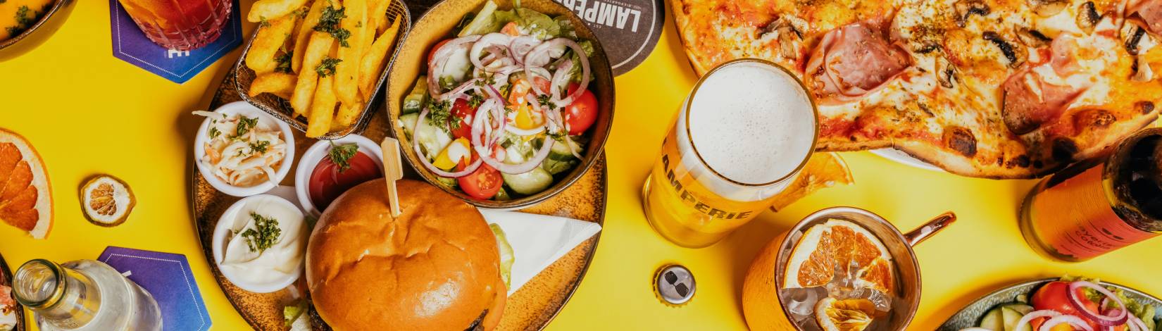 plates of pizza, hamburger, fries