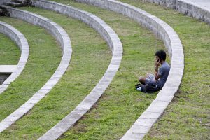 Student sitting alone on grass